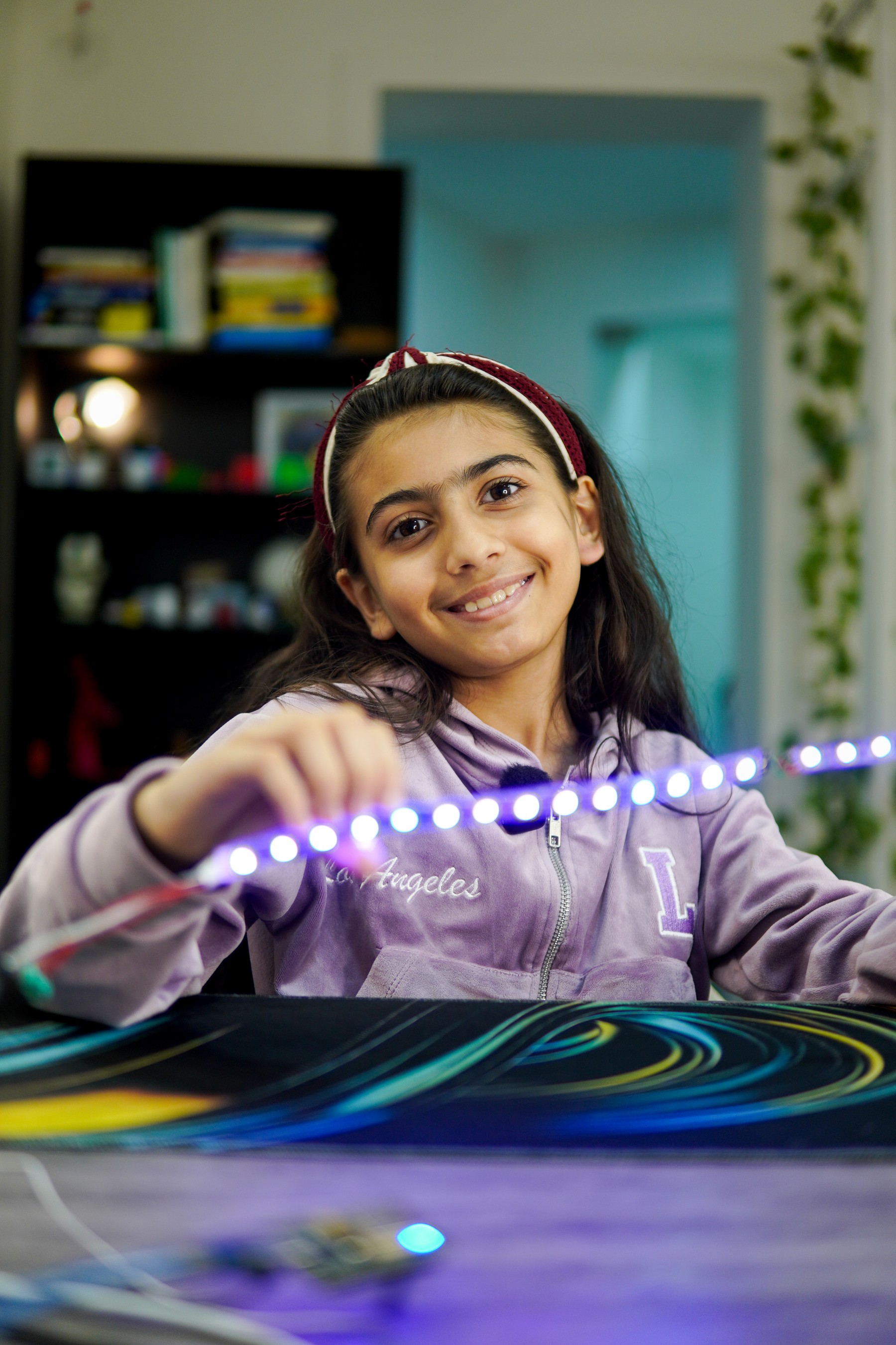 A Cubo Academy child smiling with the glowing light strip she built